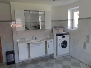 ein Badezimmer mit einem Waschbecken und einer Waschmaschine in der Unterkunft Ferienwohnung Kreiller in Johanniskirchen