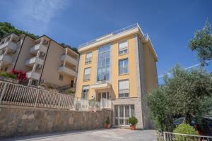 an apartment building with a retaining wall and trees at Apartments Bonazza in Petrovac na Moru
