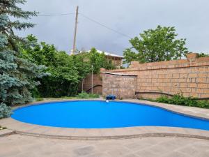 a blue swimming pool in front of a brick wall at Star Apartment in Ashtarak, Mughni in Ashtarak