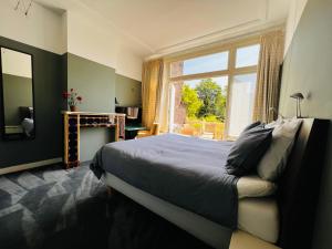 een slaapkamer met een bed en een groot raam bij Bed and Breakfast Juliana in Eindhoven