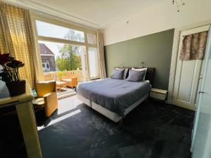een slaapkamer met een bed en een groot raam bij Bed and Breakfast Juliana in Eindhoven