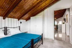 a bedroom with a bed and a wooden ceiling at Attico Verde in Kastanéa