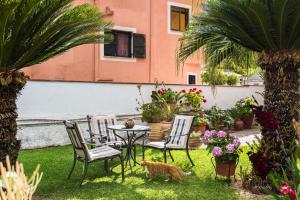 a cat walking around a table and chairs in a yard at Attico Verde in Kastanéa