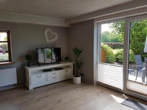 a living room with a television and a window at Ferienhaus Landleben in Sörup