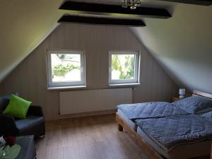 - une chambre mansardée avec un lit et 2 fenêtres dans l'établissement Ferienhaus Landleben, à Sörup