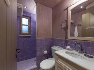 a bathroom with a sink and a toilet and a mirror at Six Keys in Afissos