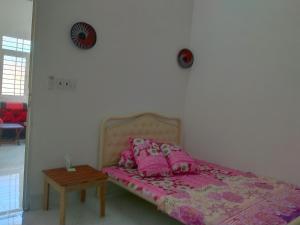 a bed with pink pillows and a table in a room at Room in Vietnam 1 in Ben Tre