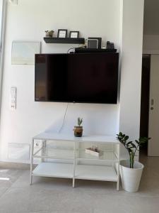 een woonkamer met een tv aan een witte muur bij Sonneland , Sonemar in Sonnenland