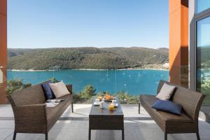 a patio with chairs and a table with a view of the water at Park Hill Residences in Rabac