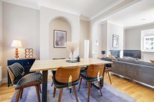 a living room with a table and chairs at Luxury 3 Bedroom 2 bathroom House, Fulham SW6 By 360Stays in London