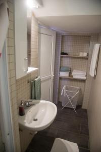 La salle de bains est pourvue d'un lavabo blanc et d'un miroir. dans l'établissement Apartmani Međugorje, à Međugorje