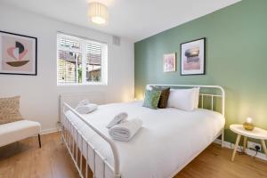 a bedroom with a white bed and a window at Luxury 3 Bedroom 2 bathroom House, Fulham SW6 By 360Stays in London