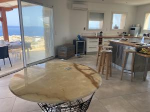 uma cozinha com uma mesa no meio de uma sala em Villa coucher de soleil sur mer em Algajola