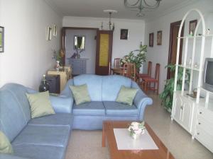 sala de estar con sofá azul y mesa en Apartamento la Fragata Nerja, en Nerja