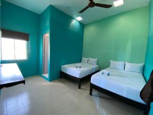 ein blaues Zimmer mit 2 Betten und einem Sofa in der Unterkunft Hotel Murallas Capital in Campeche