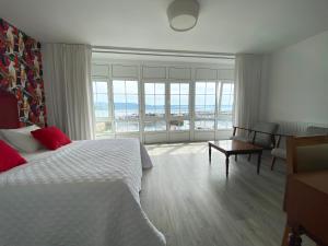 a bedroom with a bed and a view of the ocean at Pensión Residencia J. Lago in Muros
