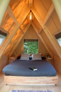 Bett in der Mitte eines Zimmers im Dachgeschoss in der Unterkunft Presanella Mountain Lodge in Temù