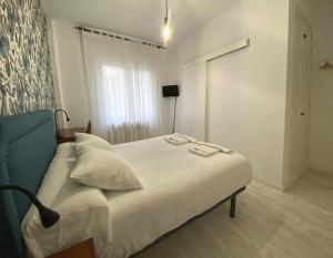 A bed or beds in a room at Pensión Residencia J. Lago