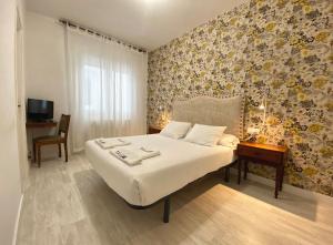 A bed or beds in a room at Pensión Residencia J. Lago