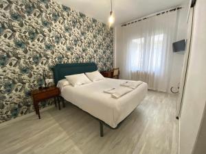 A bed or beds in a room at Pensión Residencia J. Lago