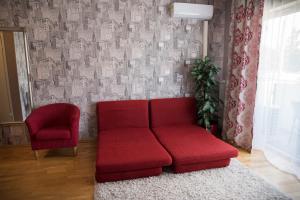 een rode bank en een stoel in de woonkamer bij Aleksandria Apartment in Pärnu