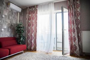 een woonkamer met een rode bank en een raam bij Aleksandria Apartment in Pärnu