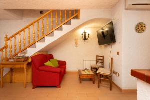 sala de estar con silla roja y escaleras en Casa perfecta para una experiencia en el Priorat, en Gratallops