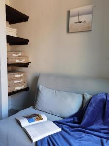 un libro sentado en una cama con una manta azul en La casa sulla Terrazza, en Sarnico