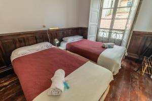 2 Betten mit ausgestopften Tieren auf einem Zimmer in der Unterkunft Hostal San Pelayo in Santiago de Compostela