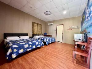 a hotel room with two beds and a flat screen tv at Juara Beach Resort in Tioman Island