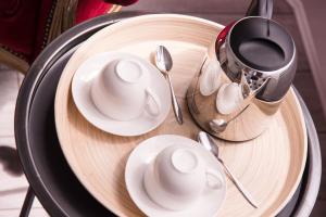 a table with white plates and spoons on a wooden plate at Chic Appart - Sauna privatif in Tourcoing