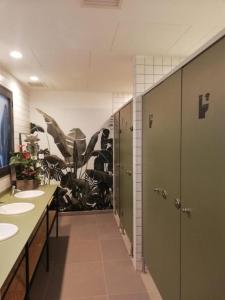 a bathroom with three sinks and a plant mural at AZ The Botanic Hostel in Zaragoza