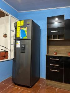 a refrigerator in a kitchen next to a counter at La Casa de Detours Costa Rica in Fortuna