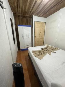a bedroom with a bed with a towel on it at La Casa de Detours Costa Rica in Fortuna