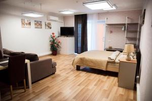ein Schlafzimmer mit einem Bett und ein Wohnzimmer mit einem Sofa in der Unterkunft Papiniidu Studio Apartments in Pärnu