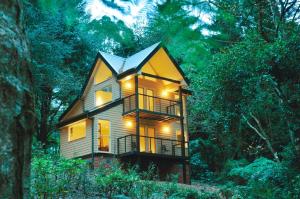 a house in the woods with its lights on at Lochiel Luxury Accommodation in Olinda