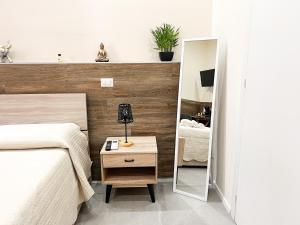 a bedroom with a bed and a night stand with a lamp at Al 115 Rooms in Cagliari