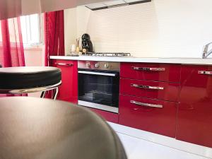 a red kitchen with red cabinets and a stove at Al 115 Rooms in Cagliari