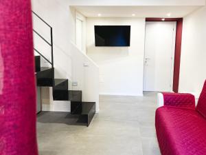 a living room with a red couch and a tv at Al 115 Rooms in Cagliari