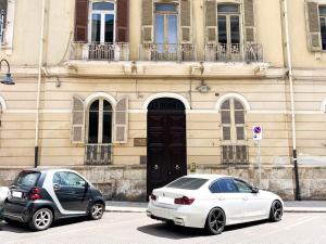 two cars parked in front of a building at Al 115 Rooms in Cagliari