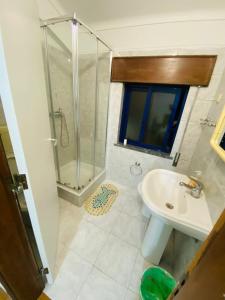 La salle de bains est pourvue d'une douche et d'un lavabo. dans l'établissement Come Inn Sesimbra, à Quinta do Conde