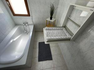 a white bathroom with a tub and a sink at Les Demoiselles du Lac in Braucourt