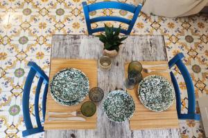 een houten tafel met stoelen en borden erop bij Casa Mirabilis 44 in Ostuni