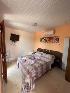 sypialnia z łóżkiem i telewizorem z płaskim ekranem w obiekcie Pousada do Gordo w mieście Bonito