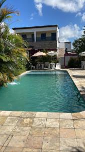 una piscina con sillas y sombrillas frente a un edificio en Pousada do Gordo en Bonito