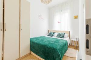 um quarto com uma cama com um cobertor verde em Petrova street em Zagreb