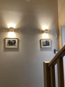 two lights on a wall with two pictures on it at COME2rest - Subaciaus 5 in Vilnius