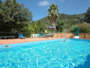 a swimming pool with a table and chairs in it at Casa Pamalù in Nisporto