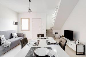 a white living room with a table and a couch at Casa SarTuga in SantʼAntìoco