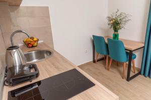 a kitchen with a sink and a table with chairs at Apartments Bonazza in Petrovac na Moru
